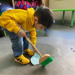 Kid doing cleaning activity at The Nurtuary Preschool, Sector 20 Panchkula