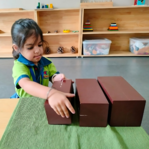 Kid engaging in Montessori Brown Stair activity at The Nurtuary Preschool in Sector 20 Panchkula